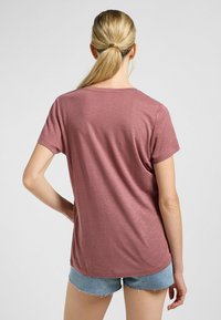 T-shirt a maniche corte, dal fit relax, in rosa polveroso. Realizzato in un morbido tessuto testurizzato con scollo a barco e orlo leggermente curvo.
