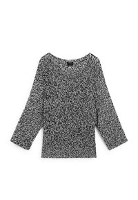Black and white knit top with a loose fit, round neckline, and three-quarter sleeves; features a textured pattern throughout.