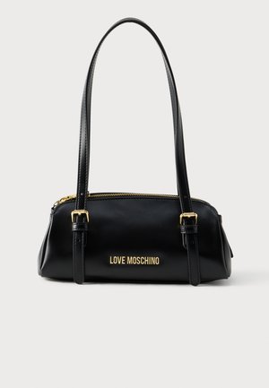 Μαύρη δερμάτινη τσάντα με διπλές λαβές, κλείσιμο με φερμουάρ και χρυσά γράμματα μάρκας στην πρόσοψη. Λείο υφή με δομημένη σιλουέτα.