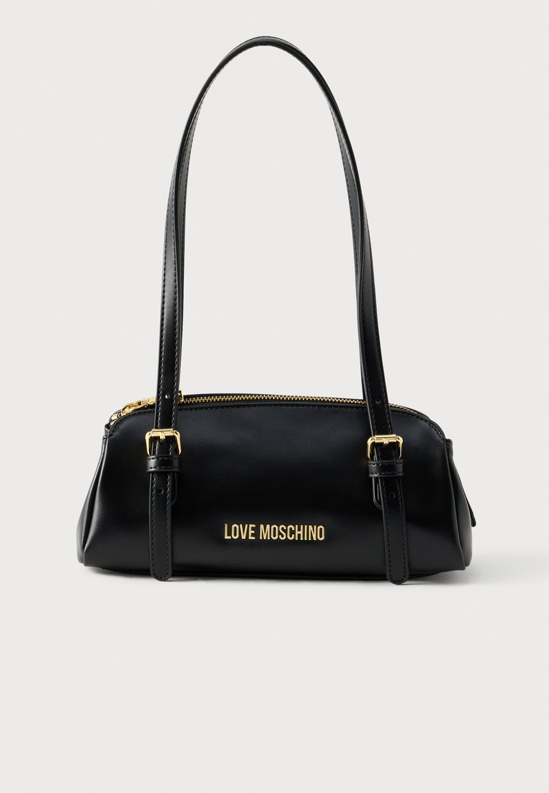 Μαύρη δερμάτινη τσάντα με διπλές λαβές, κλείσιμο με φερμουάρ και χρυσά γράμματα μάρκας στην πρόσοψη. Λείο υφή με δομημένη σιλουέτα.