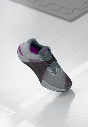 Athletic shoe featuring a gray mesh upper with purple accents, a textured outsole, and a cushioned collar for comfort.
