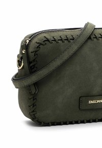 Borsa a tracolla in finta suede verde oliva con chiusura a cerniera, cuciture decorative e hardware dorato. Design compatto e strutturato.