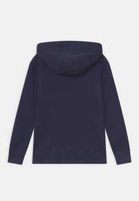 Námořnická modrá mikina s kapucí, dlouhými rukávy, žebrovanými manžetami a měkkou texturou. Na přední straně je design s klokánkovou kapsou.