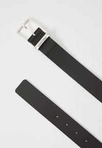 Black leather belt with a textured surface, silver metal buckle, and holes evenly spaced along the strap for adjustable sizing.