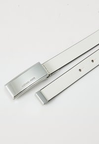 Curea din piele albă cu accesorii din argint, având o cataramă rectangulară și numele mărcii embosat. Include detalii cu cusături paralele.