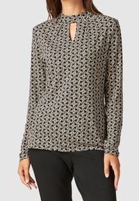 Long-sleeve top in black and cream with geometric pattern, featuring a high neckline and keyhole detail at the front. Soft fabric.