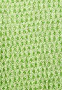 Helle grüne gestrickte Stoff mit einem offenen Spitzenmuster, das eine weiche Textur und abwechslungsreiche Stichdesigns für visuelles Interesse aufweist.