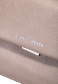Hellbeige strukturiertem Lederhandtasche mit silbernen Hardwaredetails und "GERRY WEBER"-Logo, das ein schlankes, minimalistisches Design aufweist.