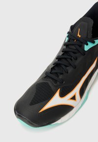 Black athletic shoe with a mesh upper, orange and white accents, and turquoise sole. Features a rounded toe and laces for secure fit.
