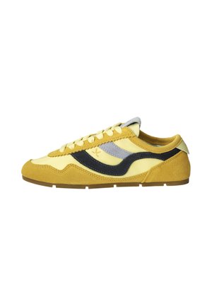 Low-profile yellow sneaker with suede details, black and gray side stripes, and cream laces on a brown rubber sole, shown from the side.