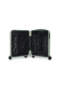 Green hard-shell suitcase open, features black lined interior with vertical white patterns, cross straps, and zippered compartment. Four wheels.