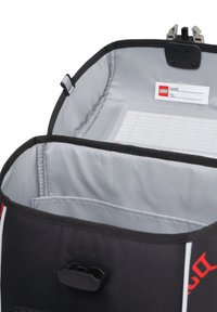 Borsa LEGO nera con interno grigio, dotata di portanome, chiusura sicura e linee bianche decorative lungo i bordi.