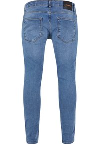 Feszes fazonú farmernadrág világoskék denim anyagból, öt zsebbel, sima felülettel és egy címkével a hátsó derékrészen.