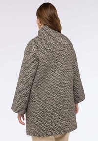 Kabát z vlněné směsi ve vzoru psí zub s vysokým límcem, volným střihem a širokými rukávy v odstínech hnědé a šedé.