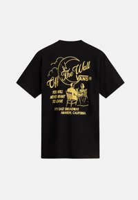 Camiseta de algodón negra que presenta un diseño gráfico amarillo de dos figuras en una mesa bajo una luna creciente, con texto y detalles de ubicación.