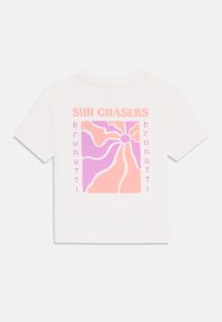 Hvit bomulls t-skjorte med et fargerikt grafisk design med svirrende mønstre i rosa og lilla, merket med «SUN CHASERS» og «brunotti». 