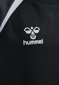 Camiseta deportiva negra con un tejido texturizado, que presenta un logo blanco de Hummel y una franja blanca en contraste a lo largo de la costura del hombro.