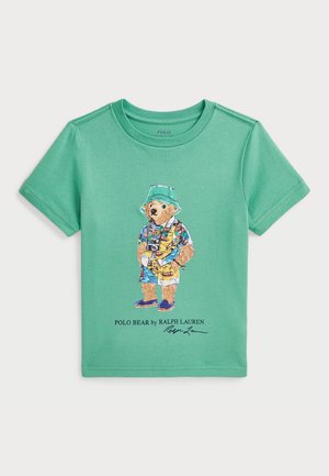 Zielona bawełniana koszulka z ilustracją niedźwiedzia w kolorowym stroju, trzymającego aparat, umieszczona nad napisem "POLO BEAR by RALPH LAUREN."