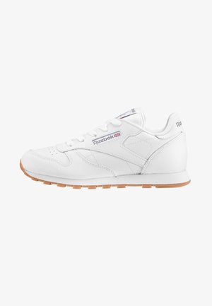 Zapatillas blancas con cordones hechas de cuero y con suela de goma. Presentan un sutil logotipo lateral y acentos texturizados. La suela de goma proporciona un contraste.