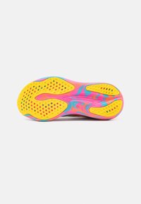 Semelle d'une chaussure de sport colorée avec des crampons jaunes et un motif tourbillonnant rose, bleu et orange sur fond blanc.
