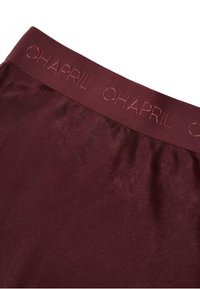 Burgundy színű leggings, széles derékrésszel, melyen dombornyomott "OHAPRIL" logó található. Simaságot és rugalmasságot biztosító anyag, karcsú megjelenéssel.