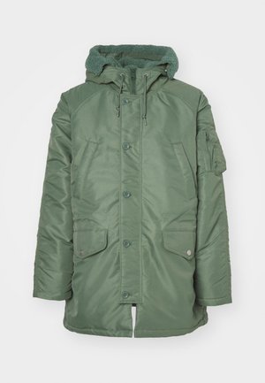 Grüne gepolsterte Jacke mit einer strukturierten Fleecekapuze, vorderen Druckknöpfen und zwei großen Seitentaschen. Verfügt über eine Reißverschlusstasche am linken Ärmel.