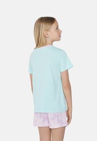 Mentolové tričko s krátkým rukávem a růžovým výstřihem, doplněné o světle fialové šortky s vzorem moře. Měkký bavlněný materiál.