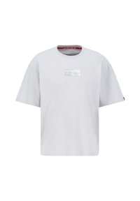 Pelēks kokvilnas T-krekls ar apaļu kakla izgriezumu, brīva piegriezuma, īsām piedurknēm, uz kura priekšpuses ir metālisks sudraba taisnstūra logo.