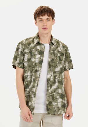 Korte mouwen, groen en wit gestreept shirt met een knopsluiting kraag, lichtgewicht stof en een relaxte pasvorm, gedragen over een wit T-shirt.