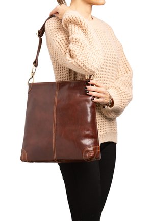 Sac à épaule en cuir marron avec une finition lisse, présentant des coutures contrastées, une large sangle et une forme carrée et structurée.