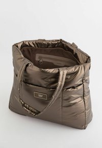 Torba na ramię w metaliczno-brązowym kolorze, z dwoma mocnymi uchwytami, posiadająca wewnętrzną kieszeń na zamek oraz przednią metkę "APRÈS SKI DOLOMITI."