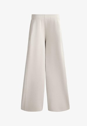 Wide-leg sweatpants in light beige fabric, featuring a smooth texture, elastic waistband, and side seam details. No pockets visible.