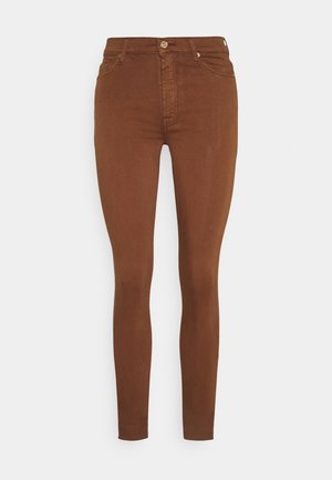 Braune High-Waist Skinny-Jeans mit vorderer Knopfleiste und Reißverschluss, im Fünf-Taschen-Stil, vor hellem Hintergrund präsentiert.