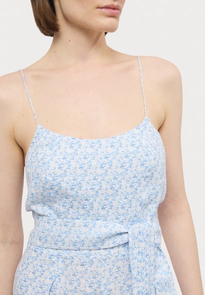Top sem mangas de flores azul claro com alças finas, apresentando uma textura suave e um detalhe de laço na cintura, feito de material leve.
