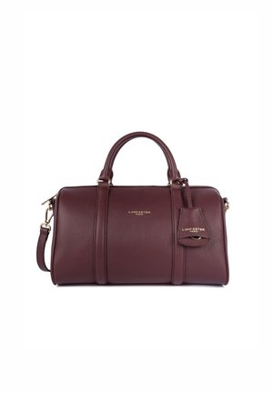 Sac à main en cuir bordeaux avec un design structuré, double poignées, une bandoulière détachable et des finitions dorées. Caractéristiques d'un logo et d'un détail d'étiquette.