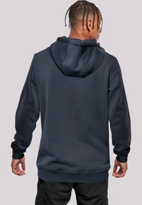 Navy blue hoodie made of soft, textured fabric. Features a kangaroo pocket, ribbed cuffs, and a drawstring hood.