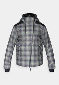 Chaqueta impermeable con un patrón de cuadros en gris y verde, acentos negros en los hombros, capucha ajustable y dos bolsillos laterales con cremallera.