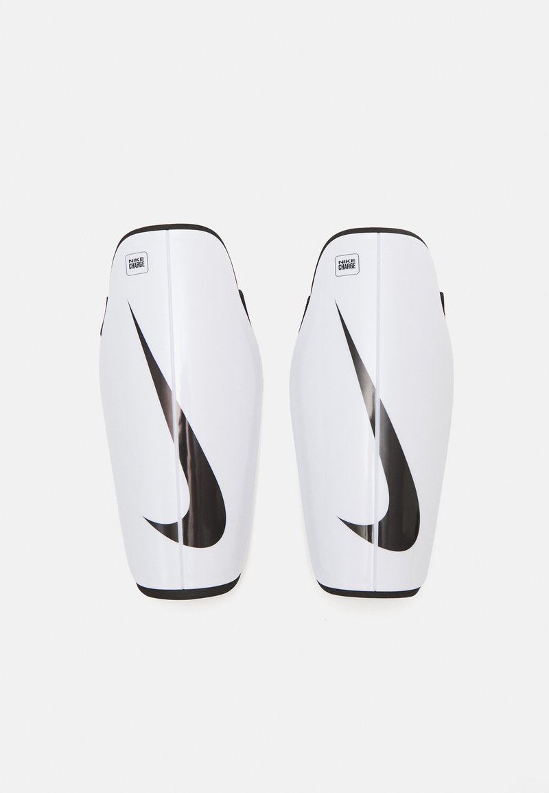 Hvide Nike skinnebeskyttere med et sort swoosh-logo. Glat plastmateriale, formet design, afrundede kanter og et lille mærke på toppen.
