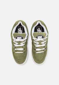 Baskets en daim vert avec des lacets blancs et une semelle en caoutchouc. Présentent un logo Vans noir et blanc sur la languette. Embout perforé pour la ventilation.