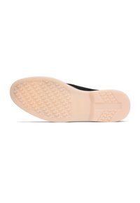 Black shoe with a textured upper, featuring a cream rubber sole. The sole has a pattern for traction, highlighting durability and design.