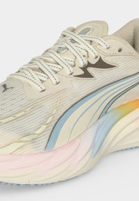 Αθλητικό παπούτσι σε κρεμ απόχρωση με υφή διχτυού, λευκά κορδόνια, μπλε και μπεζ ρίγες και πολύχρωμο παστέλ βαθμιαίο χρώμα στη σόλα.