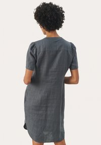 Robe en lin gris avec manches bouffantes courtes, coupe légèrement évasée et fentes latérales. Design épuré avec encolure arrondie et texture visible.