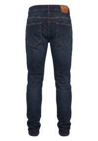 Tmavě modré džínové kalhoty v úzkém střihu, s pěti kapsami a koženou záplatou na zadní straně. Tkanina má hladkou texturu a minimální vyblednutí.