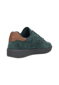 Tenisi verzi din suede cu talpă de cauciuc închis, accent din piele maro la călcâi și design cu șireturi. Suprafață texturată și profil elegant.
