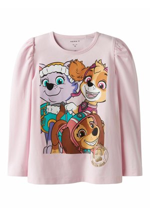 Lichtroze shirt met lange mouwen met op de voorkant drie lachende animatiepups uit een kinderprogramma, gekleed in kleurrijke reddingsuitrusting.