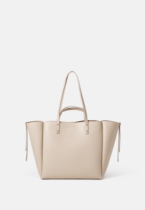 Beige tote bag made from textured leather, featuring two structured handles, gold hardware accents, and side drawstring details.