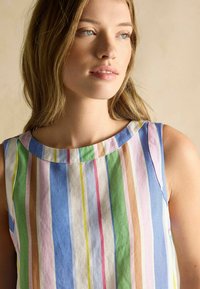 Kleit ilma varrukateta, millel on vertikaalsed triibud sinises, rohelises, roosas ja kreemjas värvitoonis. Valmistatud kergest kangast, ümara kaeluse ja vabalt langemisega lõikega.