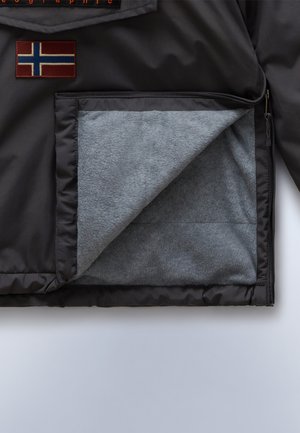 Melnas āra jakas audums ar mīkstu pelēku flīsu oderi. Iekļauj Norvēģijas karoga plāksteri un ar rāvējslēdzēju aizveramu kabatu. Viegli gluda tekstūra kopumā.