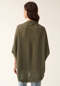 Olijfgroen, lose-fitting, gestructureerde poncho met een kraag en wijde mouwen, die over de schouders valt, met een zoom die onder de taille uitkomt.