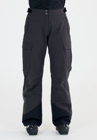 Schwarze wasserdichte Skihosen mit lockerer Passform, verstärkten Knien und mehreren Taschen. Sie verfügen über eine glatte Textur und kontrastierende dunkle Akzente.